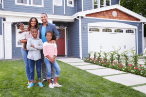 Family of 5 outside of large blue home