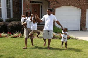 Happy family of 5 outside of home in matching outfits
